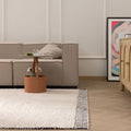Handwoven black and cream shaggy wool rug with a thick, textured pile in a modern living room setting.