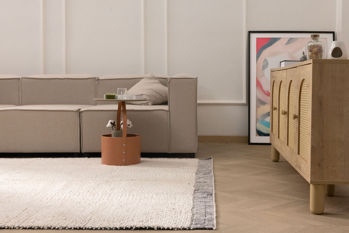 Handwoven black and cream shaggy wool rug with a thick, textured pile in a modern living room setting.