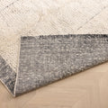 Handwoven black and white shaggy wool rug with a thick, textured pile and durable cotton backing on a wooden floor.