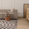 Handwoven black and white checkered shaggy wool rug with a thick, soft pile in a modern living room setting.