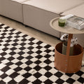 Handwoven black and white checkered shaggy wool rug with a thick, soft pile texture in a modern living room setting.