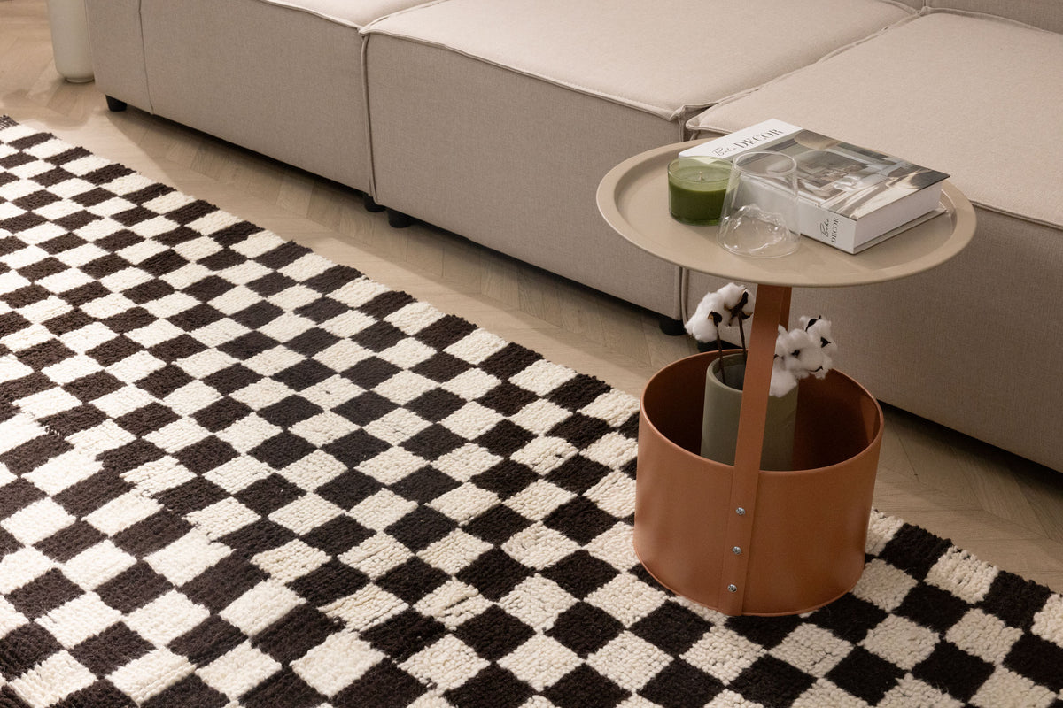 Handwoven black and white checkered shaggy wool rug with a thick, soft pile texture in a modern living room setting.