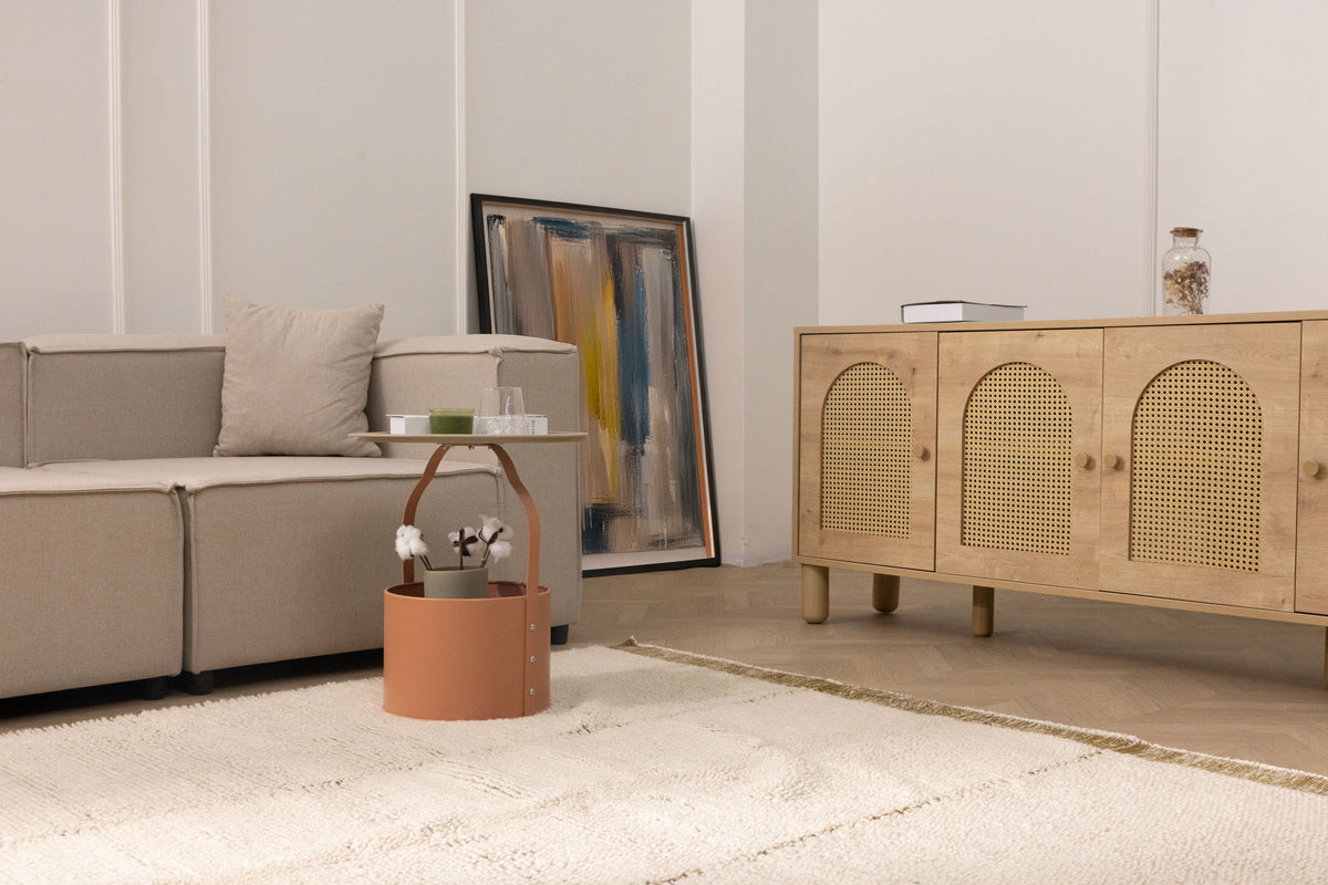 Cream-colored handwoven shaggy wool rug with a thick pile and fringed edges in a cozy, modern living room setting.