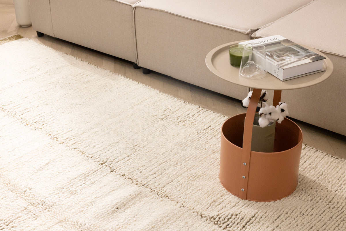 Cream-colored handwoven shaggy wool rug with a thick, textured pile placed in a cozy living room setting.