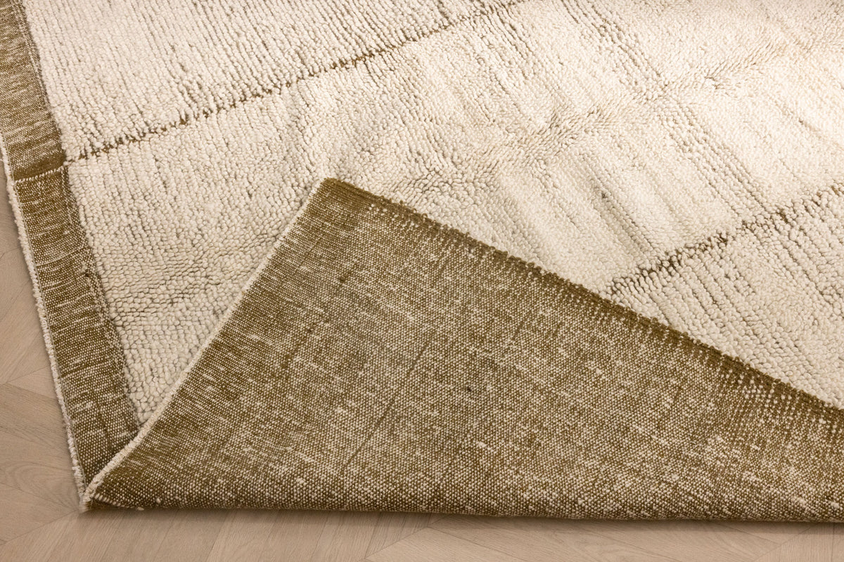 Handwoven army green and cream shaggy wool rug with a thick, textured pile and durable cotton-blend backing.