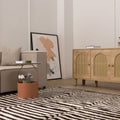 Handwoven black and white striped shaggy wool rug with a thick, soft pile texture in a cozy modern living room.