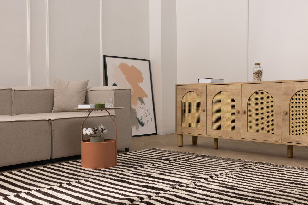 Handwoven black and white striped shaggy wool rug with a thick, soft pile texture in a cozy modern living room.