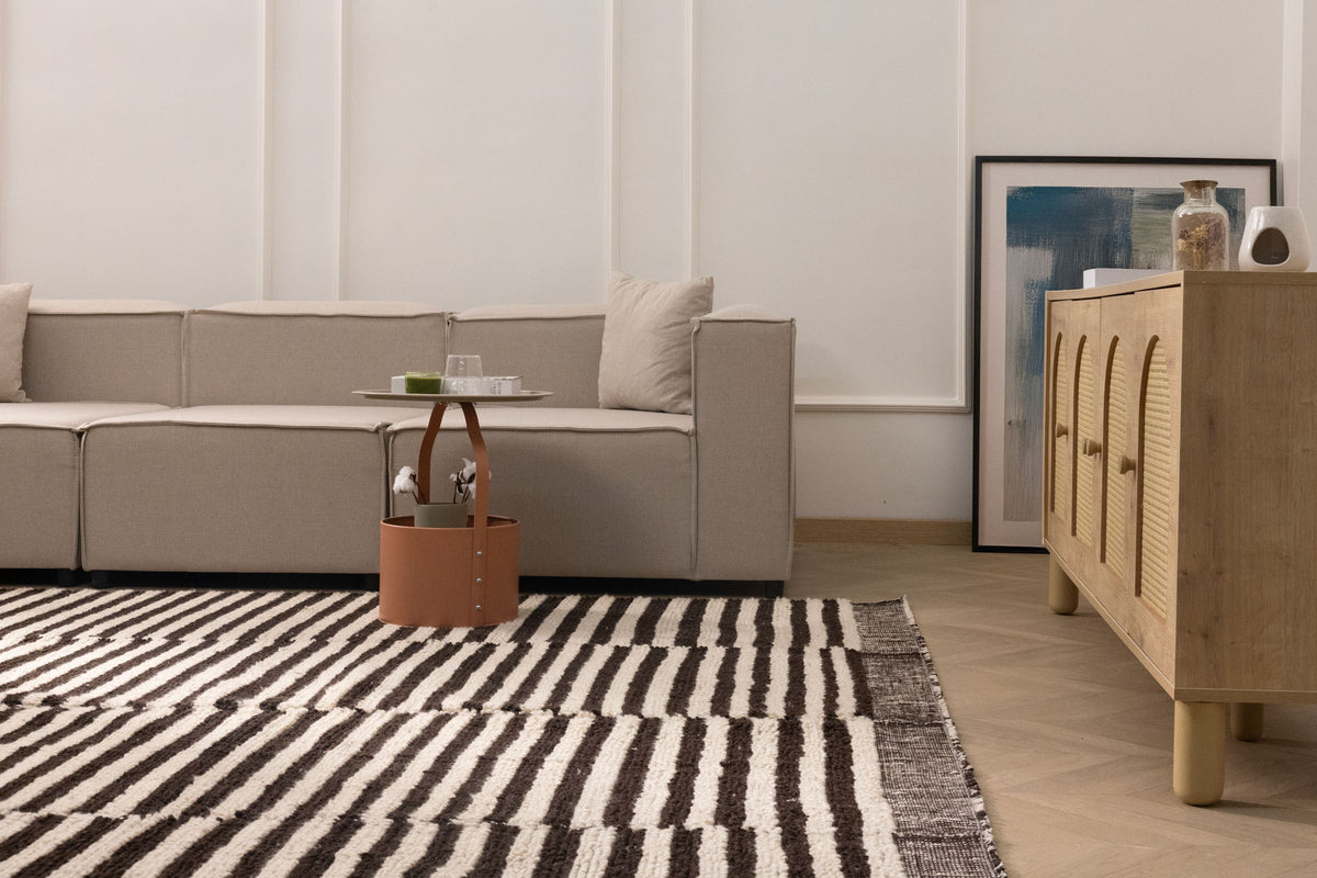 Handwoven shaggy wool rug with a black and white striped pattern, featuring a thick, high-pile texture in a modern living room.