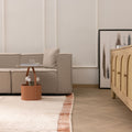 Handwoven terracotta and cream shaggy wool rug with a thick, soft pile texture in a cozy modern living room.