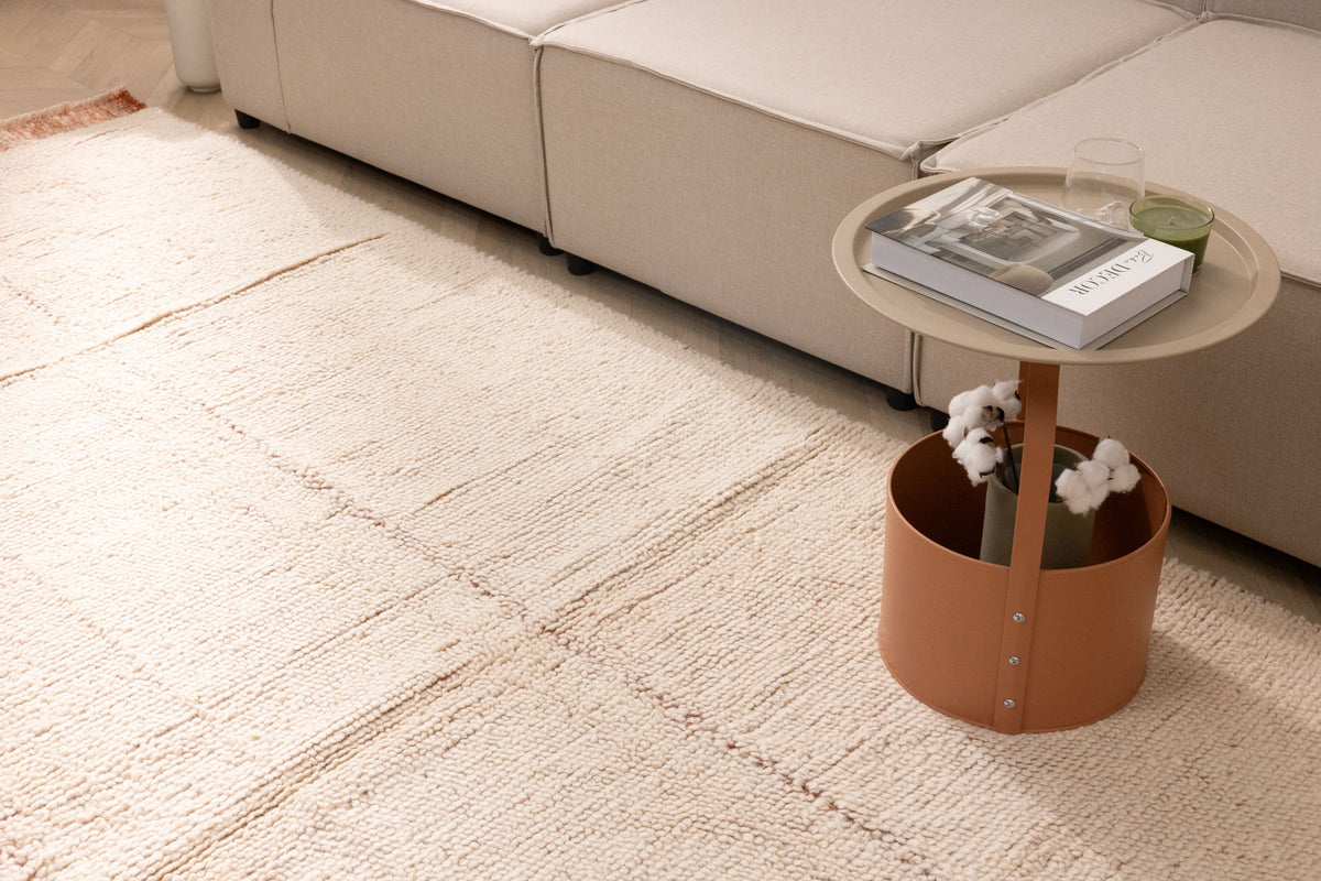 Handwoven terracotta shaggy wool rug with a thick, textured high-pile design in a cozy, modern living room setting.