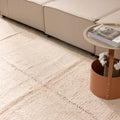 Handwoven terracotta shaggy wool rug with a thick, textured pile in a cozy living room setting.