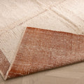 Handwoven terracotta and cream wool shaggy rug with a high pile texture and durable cotton-blend backing.