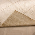 Dark mustard shaggy wool rug with a thick, textured pile and a folded corner revealing the smooth, durable backing.