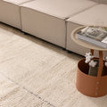 Silver gray shaggy wool rug with a thick, handwoven high-pile texture placed in a cozy, modern living room setting.