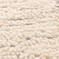 Close-up of a thick, silver-gray shaggy wool rug with a soft, handwoven high-pile texture and dense, cozy fibers.