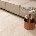Handwoven white shaggy wool area rug with a thick, textured pile placed in a cozy modern living room.