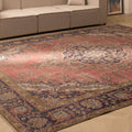 Oversized pink and navy Persian-style wool-cotton rug with intricate floral patterns in a bohemian living room.