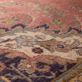 Oversized pink Persian-style area rug with intricate floral motifs, handmade from wool and cotton in a traditional bohemian design.