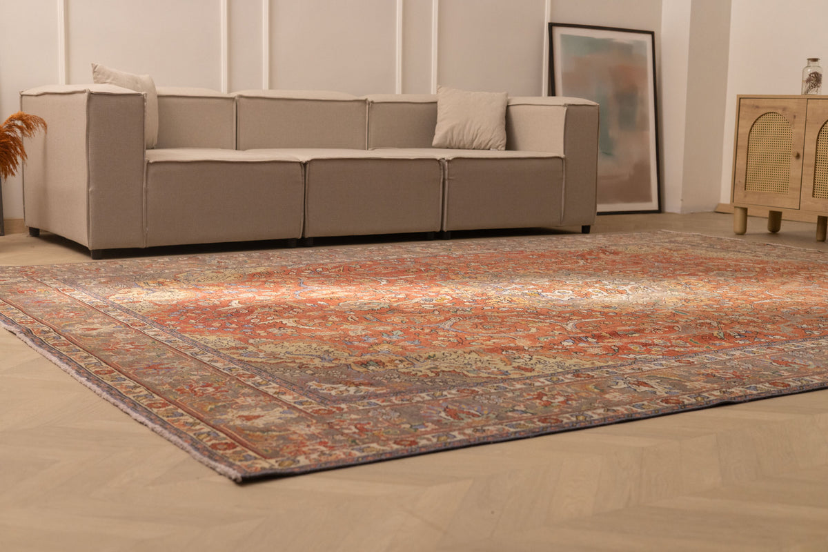 Oversized red Persian-style wool and cotton area rug with intricate floral patterns in a modern living room.