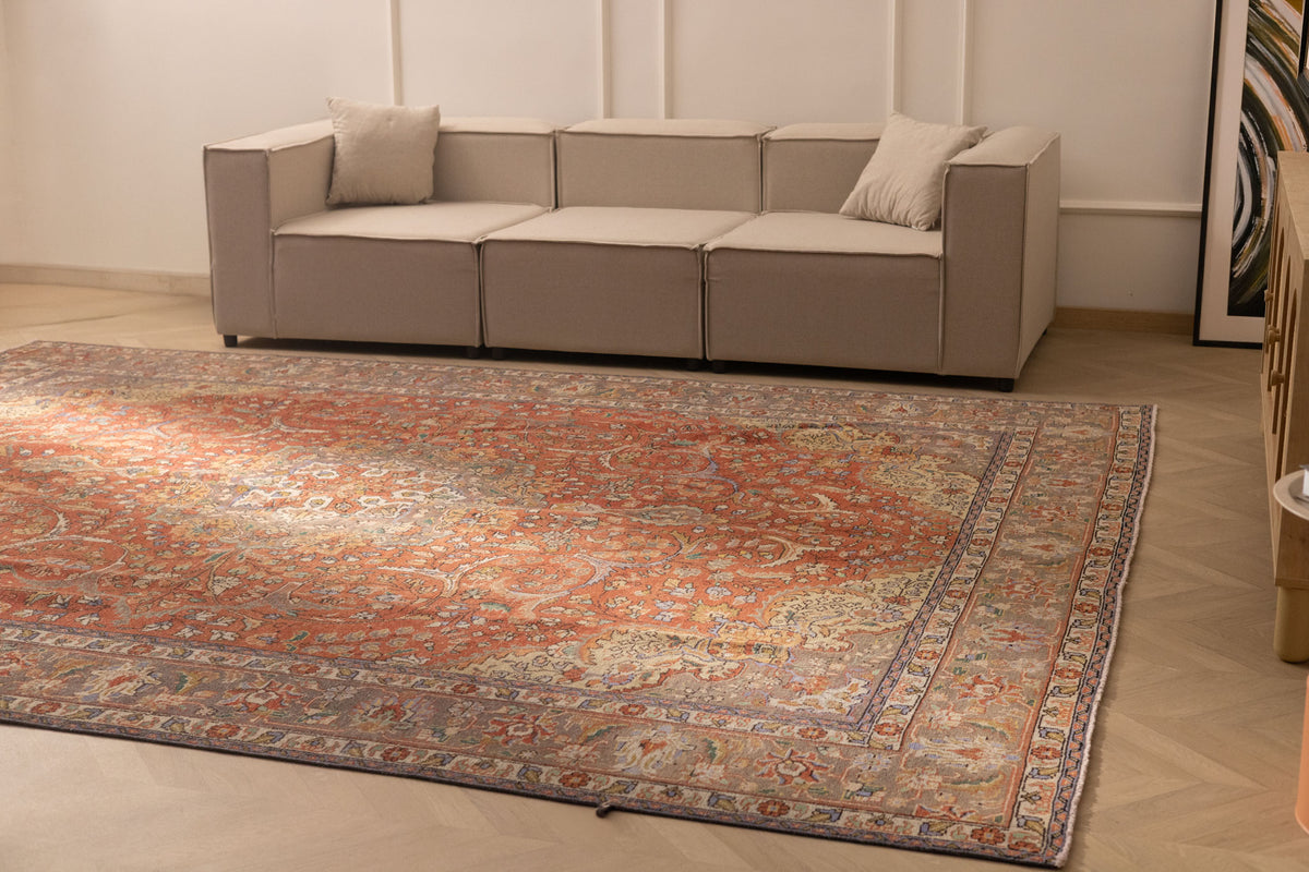 Oversized red Persian-style wool and cotton area rug with intricate floral patterns in a modern living room.