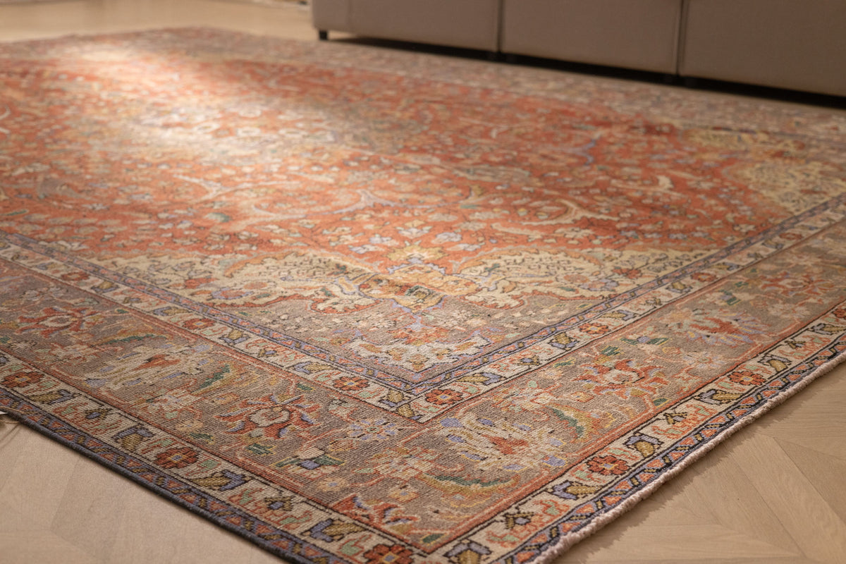 Oversized red Persian-style area rug with intricate floral patterns, crafted from a wool and cotton blend.