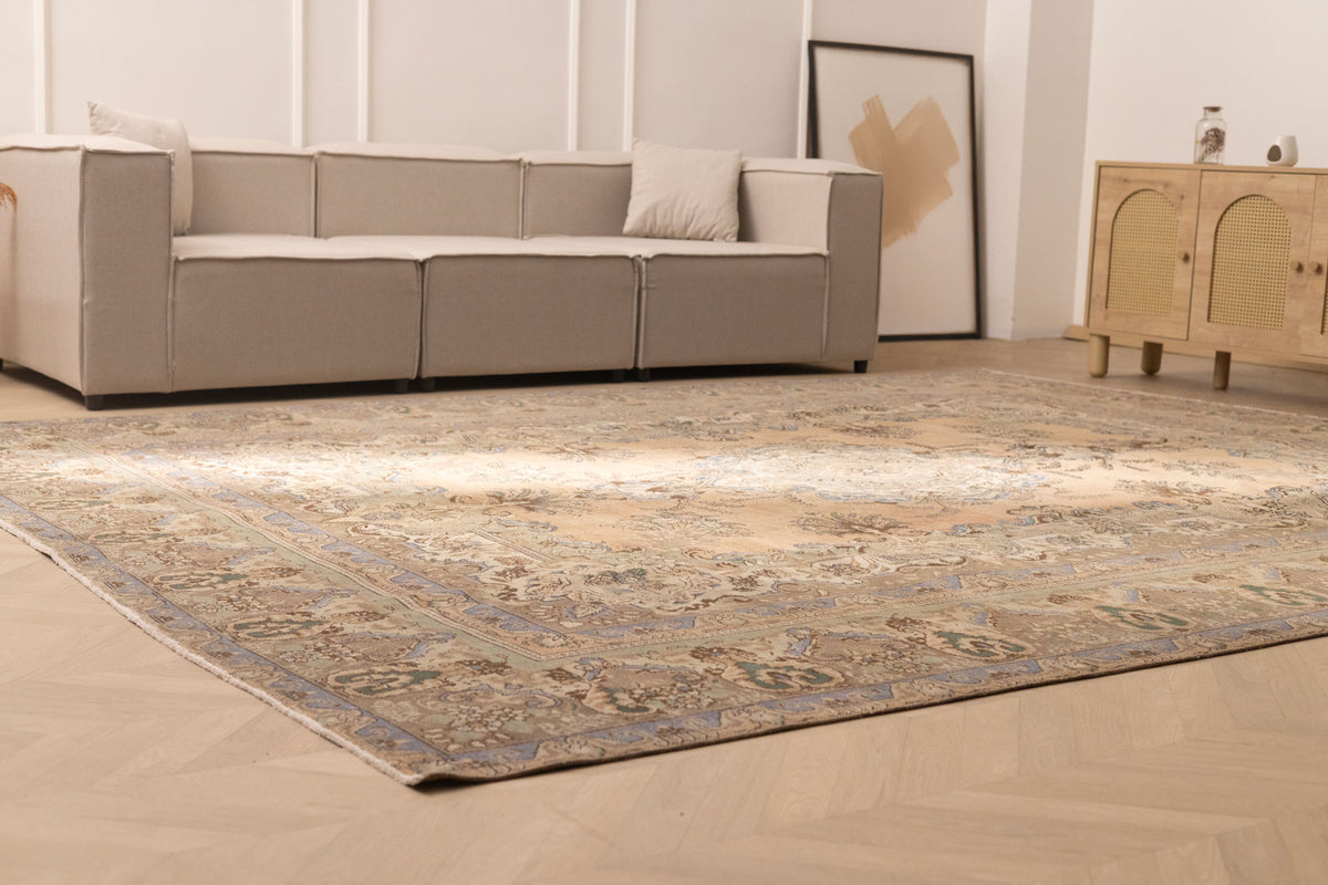 Oversized wool and cotton Persian-style area rug in brown and green floral patterns in a modern farmhouse living room.