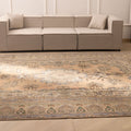 Oversized Persian-style wool and cotton area rug in brown and green with intricate floral motifs in a farmhouse living room.