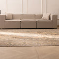 Oversized handmade wool and cotton Persian-style rug with brown and green floral patterns in a modern living room.