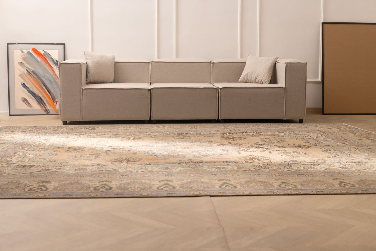 Oversized handmade wool and cotton Persian-style rug with brown and green floral patterns in a modern living room.