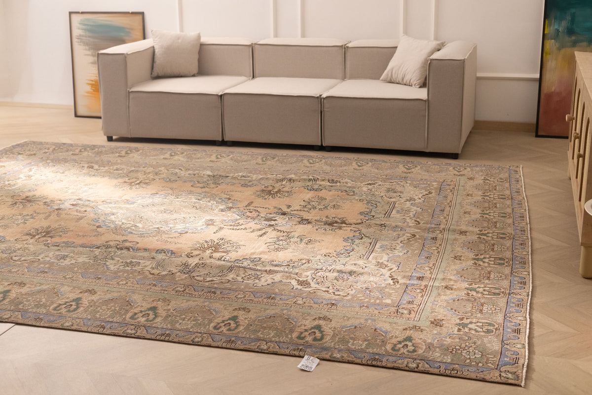 Oversized wool and cotton Persian-style area rug featuring brown and green floral patterns in a maximalist farmhouse design.