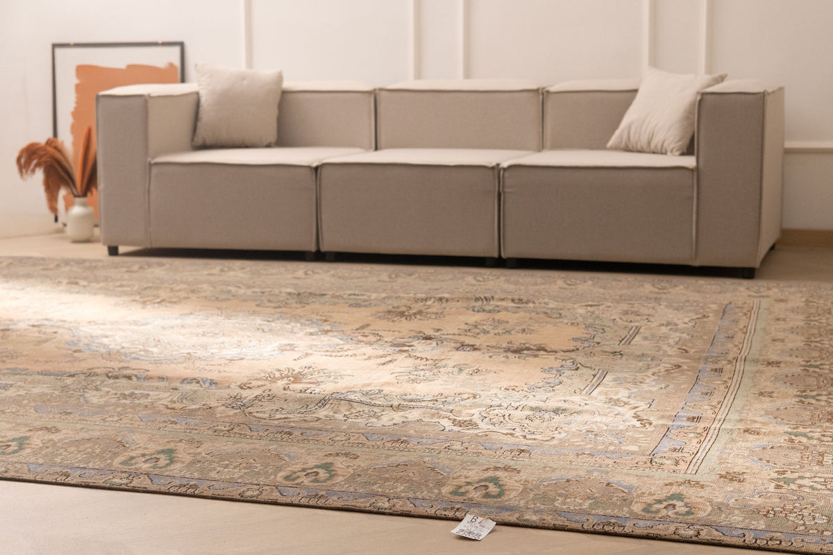 Oversized Persian-style wool and cotton area rug in brown and green floral patterns in a modern farmhouse living room.