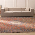 Oversized wool and cotton Persian-style rug in red and navy with intricate floral patterns in a living room.