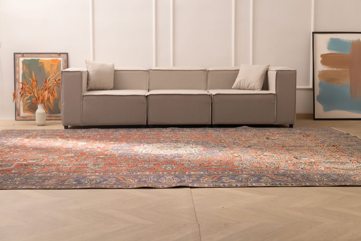 Oversized red and navy Persian-style wool and cotton area rug with intricate floral patterns in a modern living room.