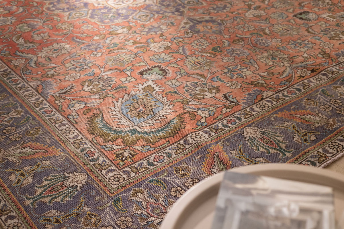 Oversized Persian-style wool and cotton area rug featuring red and navy floral patterns in a traditional bohemian design.