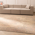 Oversized beige Persian-style wool and cotton area rug with intricate floral motifs in a traditional bohemian living room.