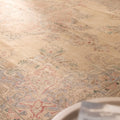 Oversized beige Persian-style wool and cotton area rug featuring intricate floral motifs and traditional bohemian patterns.