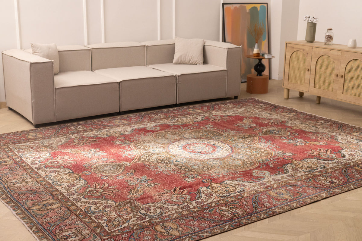 Oversized red and white Persian-style wool-cotton rug with intricate floral patterns in a modern living room setting.