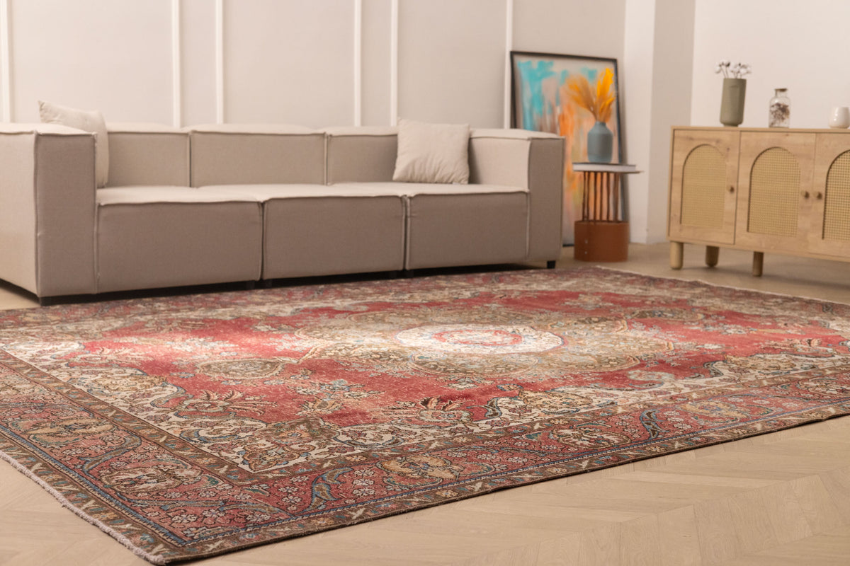 Oversized red Persian-style wool and cotton rug with intricate floral patterns in a bright, modern living room.