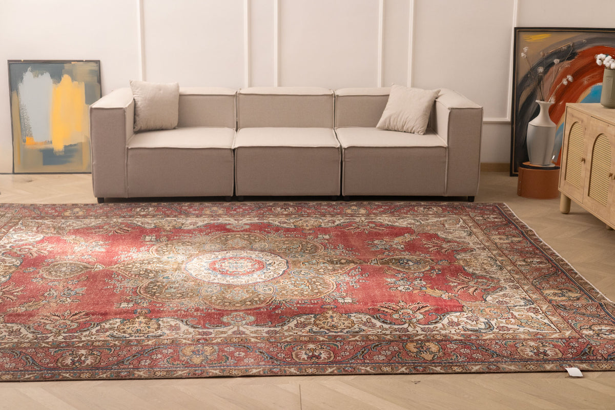 Oversized red and white Persian-style wool and cotton area rug with intricate floral motifs in a living room setting.