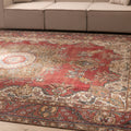 Oversized red and white Persian-style wool and cotton area rug with intricate floral motifs and traditional bohemian patterns.