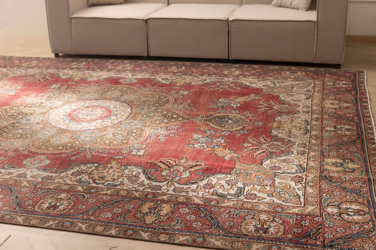 Oversized red and white Persian-style wool and cotton area rug with intricate floral motifs and traditional bohemian patterns.