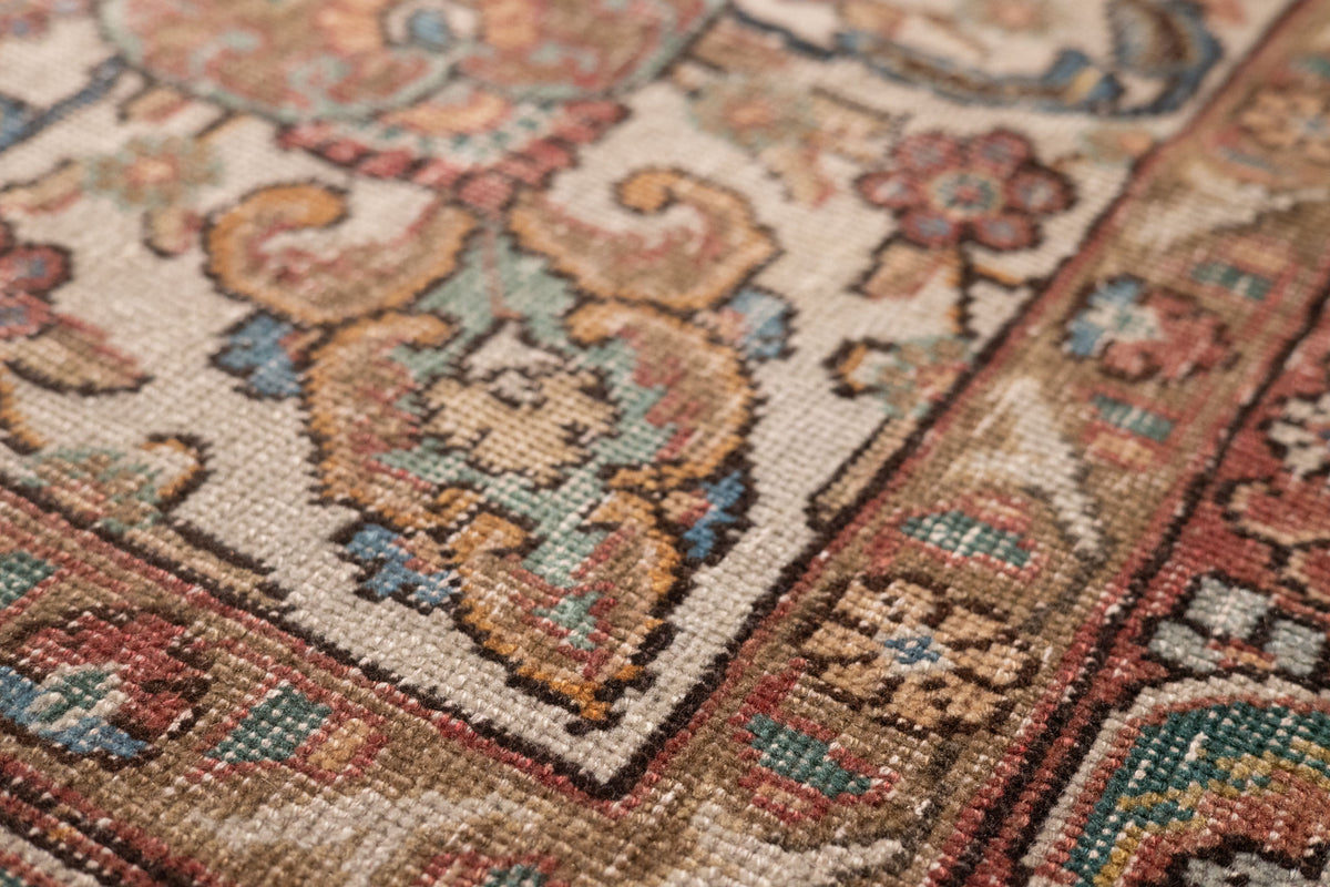 Handmade wool and cotton Persian-style rug with intricate red, white, and floral maximalist patterns.