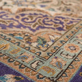 Handmade wool and cotton Persian-style rug with orange and navy floral patterns in a low-pile, bohemian design.
