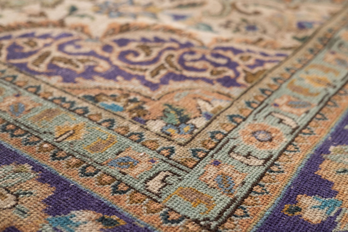Handmade wool and cotton Persian-style rug with orange and navy floral patterns in a low-pile, bohemian design.