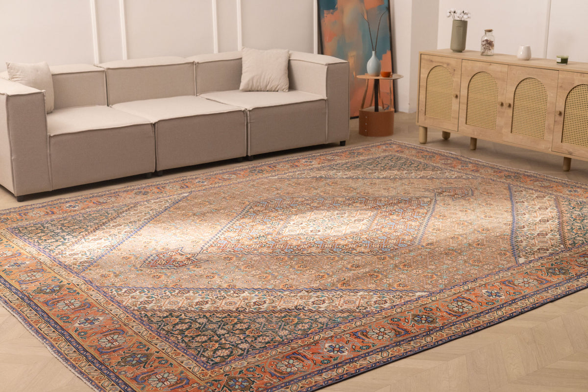 Oversized brown Persian-style wool and cotton rug with intricate floral patterns in a traditional living room.