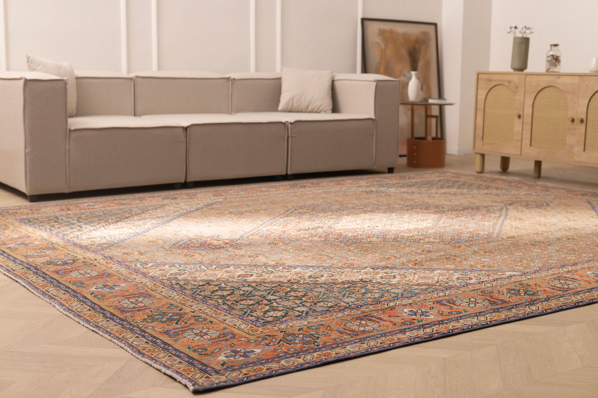 Oversized brown Persian-style wool and cotton area rug with intricate floral patterns in a traditional living room.