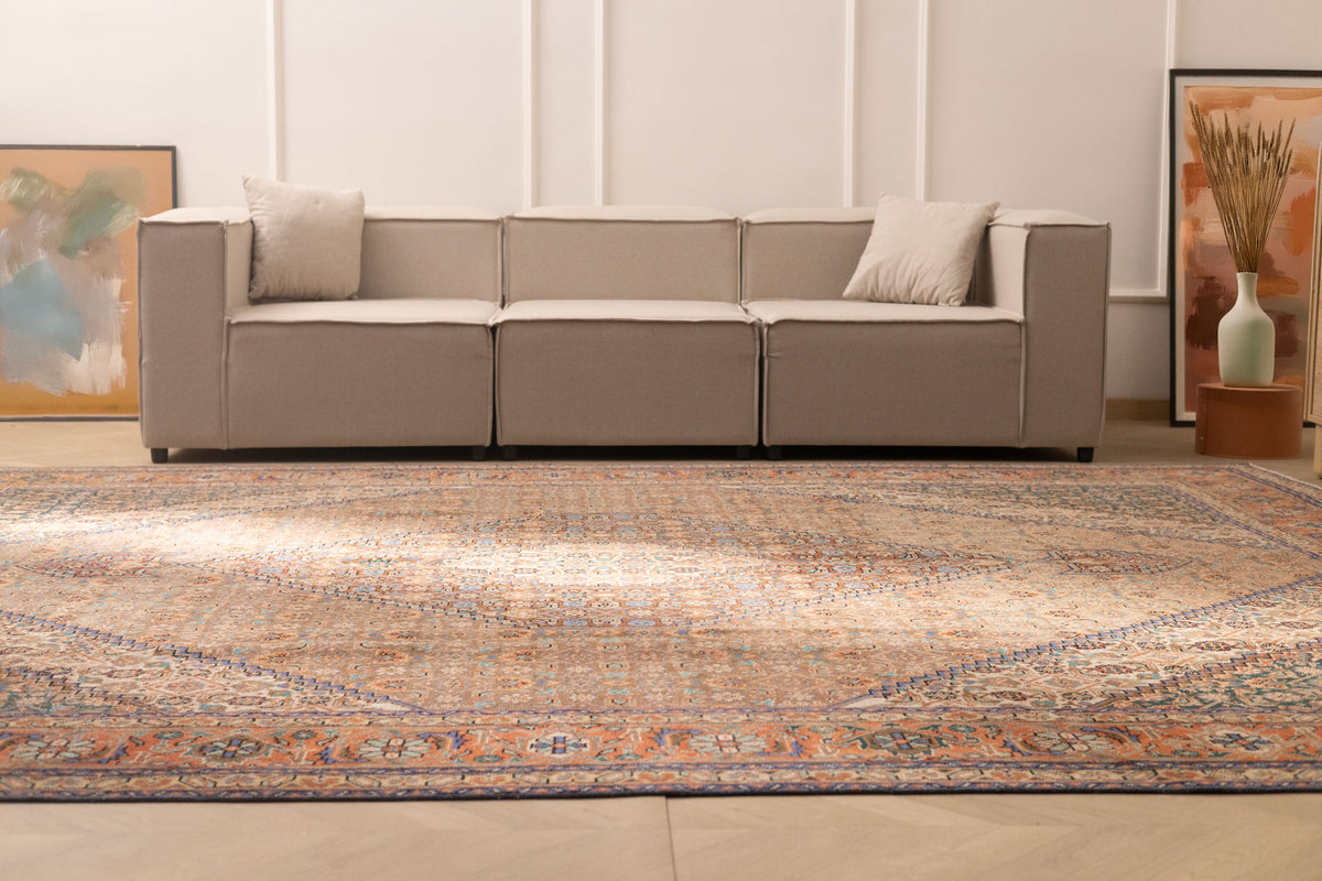 Oversized brown Persian-style wool and cotton area rug with intricate floral patterns in a modern living room.