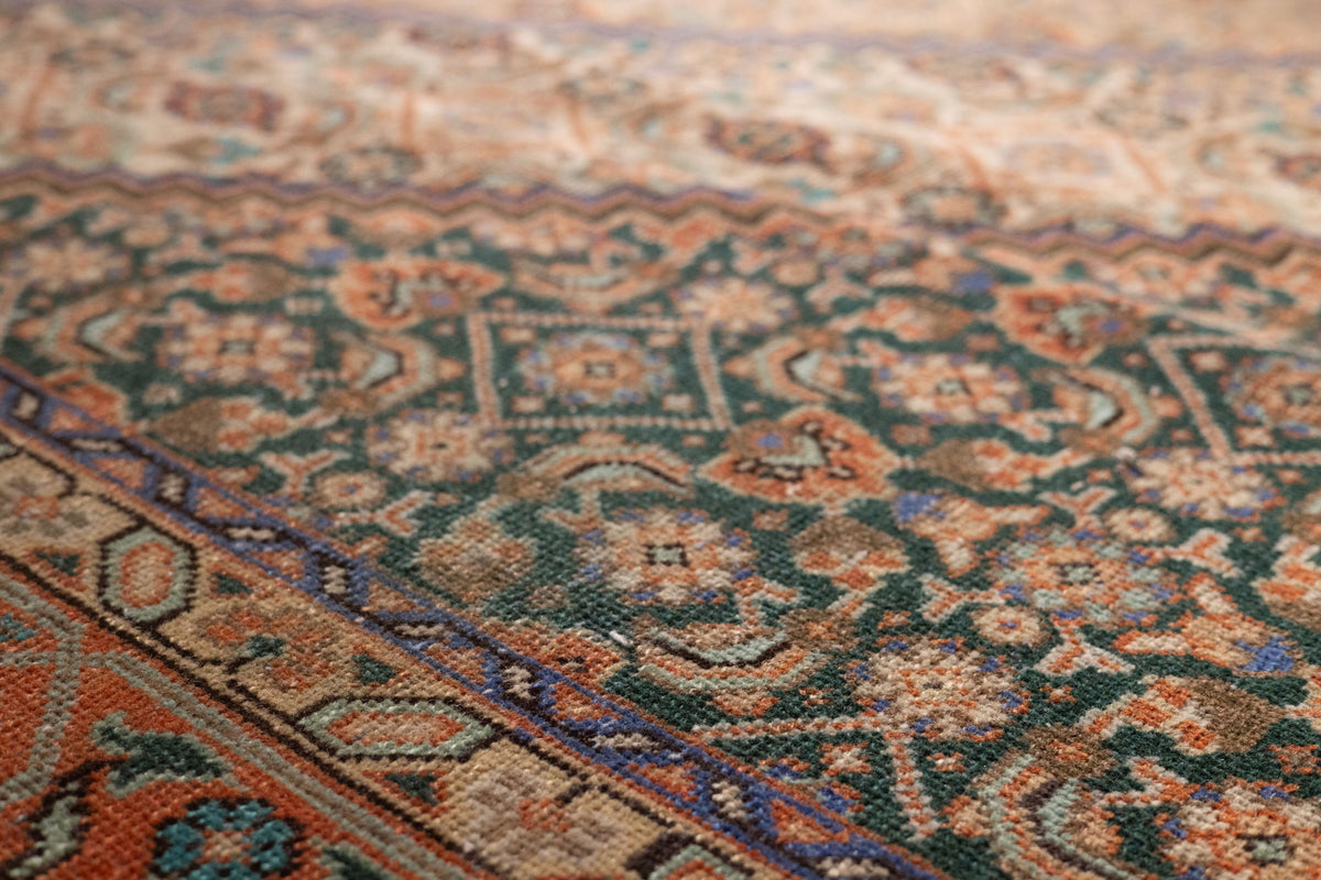 Handmade Persian-style wool and cotton area rug featuring intricate brown and green floral patterns.