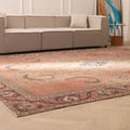 Oversized 9x12 Persian-style wool and cotton rug featuring traditional brown floral patterns in a living room setting.