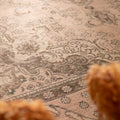 Oversized beige Persian-style wool and cotton rug featuring intricate traditional floral patterns and a low-pile texture.